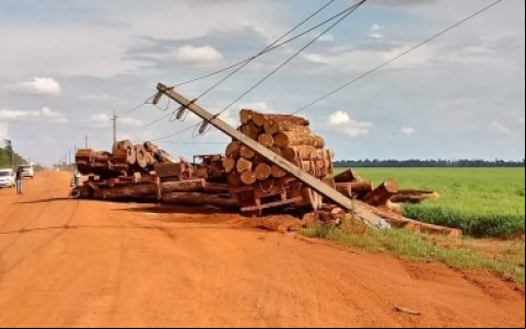 Carreta carregada com madeira bate em poste, tomba e motorista morre em MT